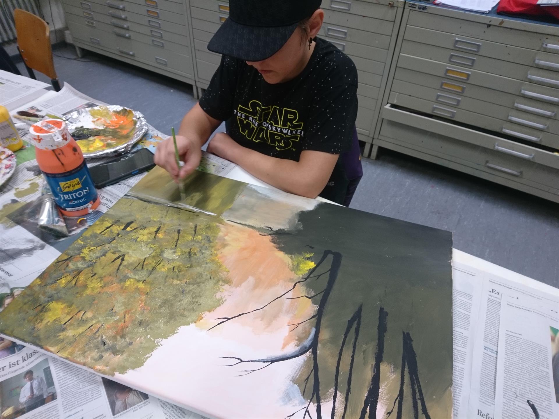 Ein Mensch malt ein Bild in der Kunst- und Musikschule Brühl