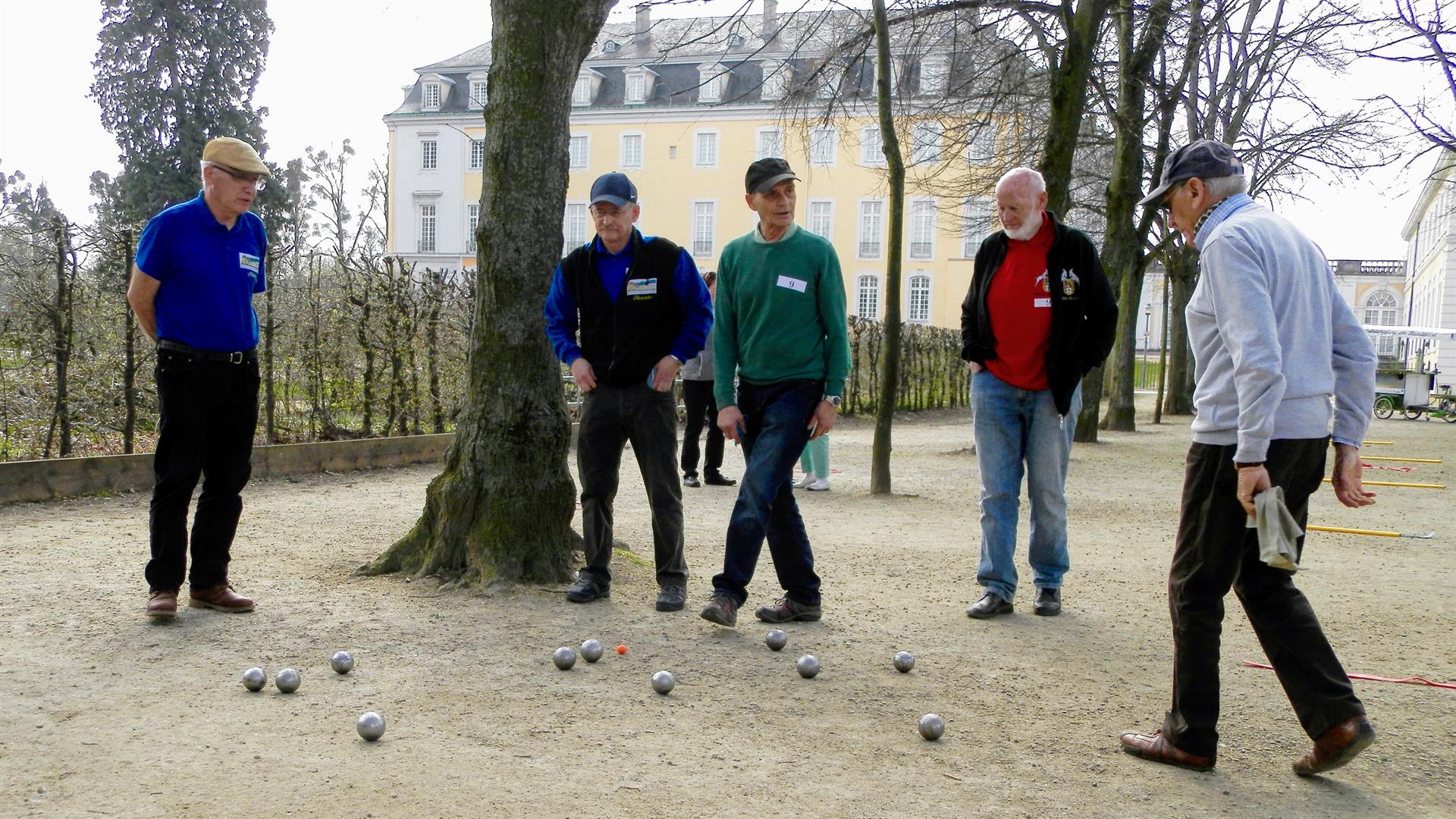 Boulespielende mit Schloss im Hintergrund